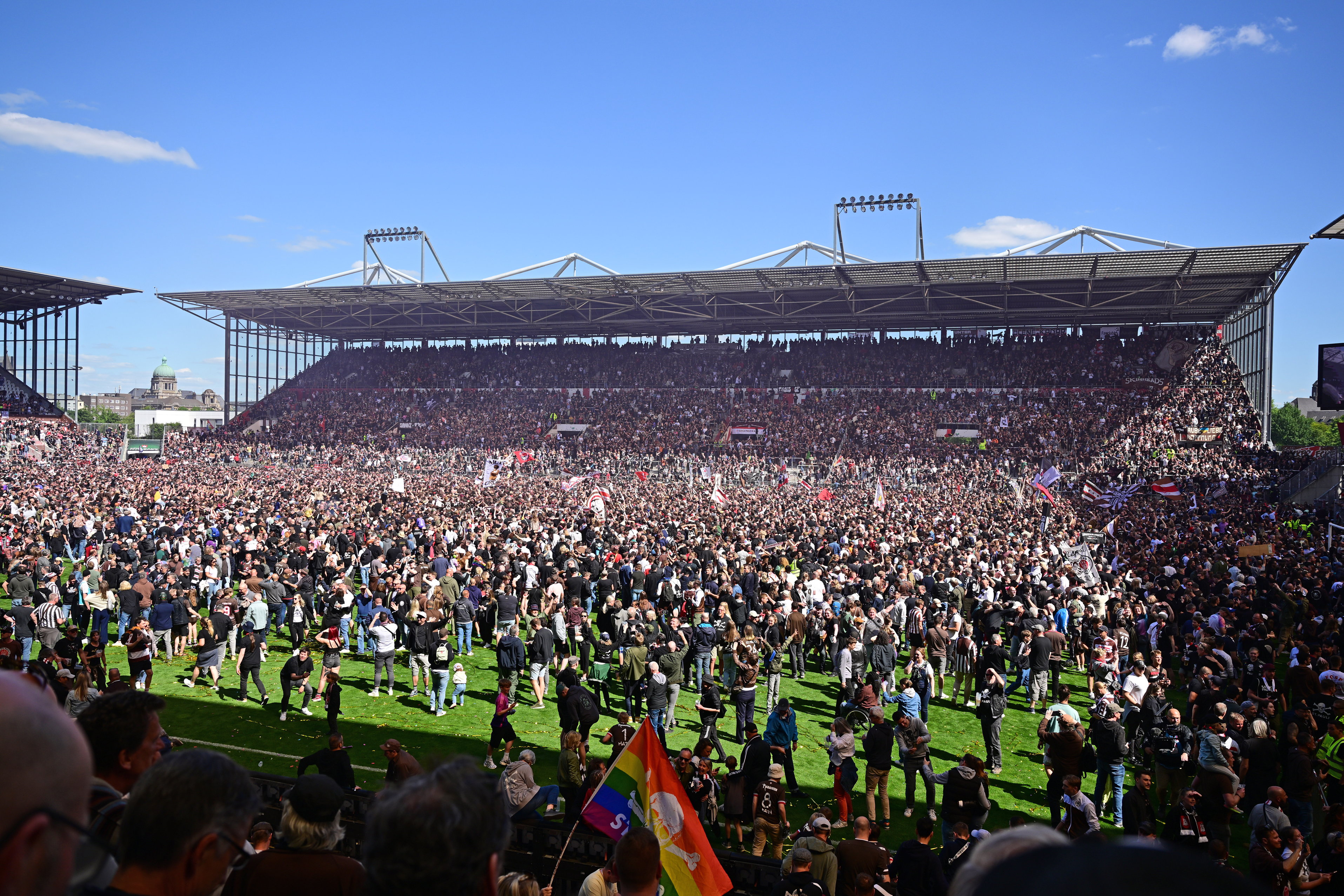 Foto vom Millerntor-Stadion mit tausenden Fans, die auf dem Rasen den Aufstieg feiern.